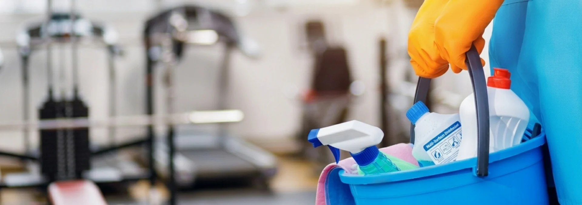 Carrinho com produtos de limpeza em ambiente de academia.
