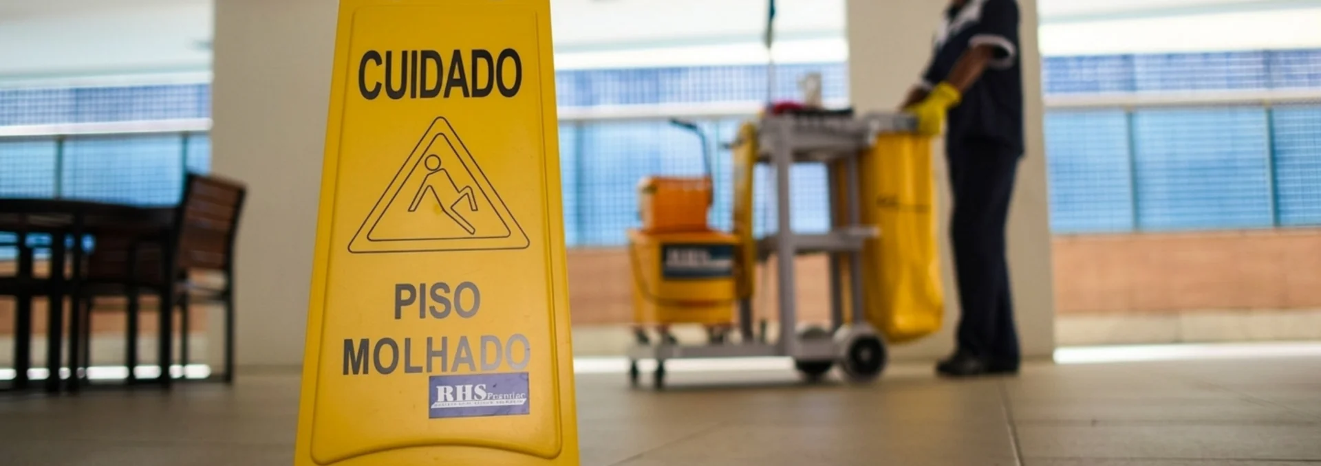 Sinalização de piso molhado em área comum de condomínio.