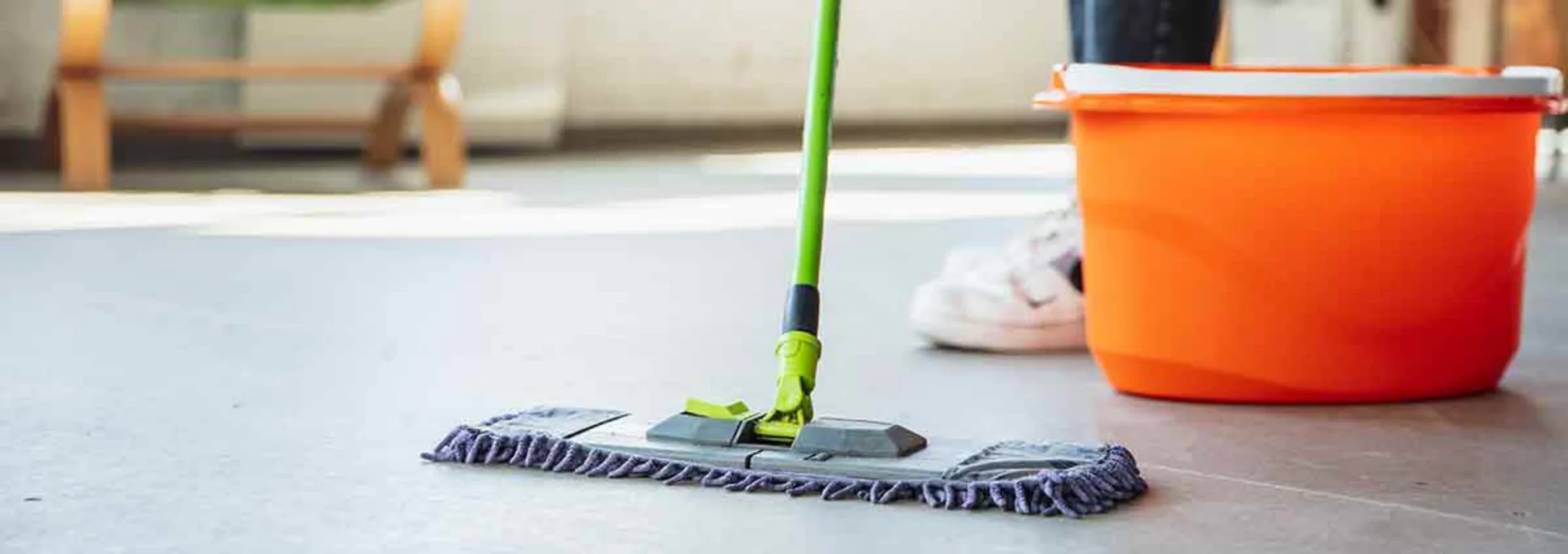 Mop e balde em piso de área comercial.
