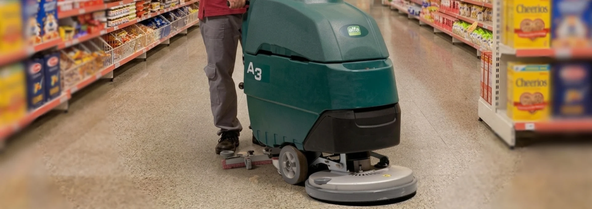 Operador usando lavadora de piso em supermercado.